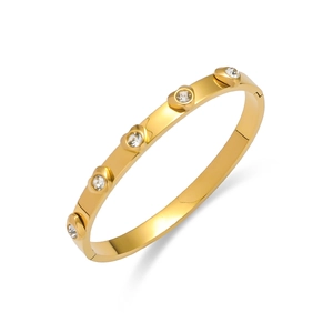 Détail d'un bracelet en acier titane doré avec 5 zircons ronds et fermoir à charnière
