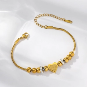 Macro shot of gold stainless steel snake chain with crystal beads and heart charm detail