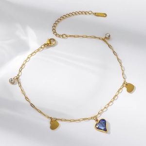 Detailed macro of gold titanium steel chain featuring blue heart crystal and charms