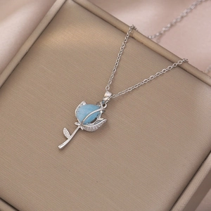 Detail of silver rose pendant with blue frosted resin bud and pavé set cubic zirconia