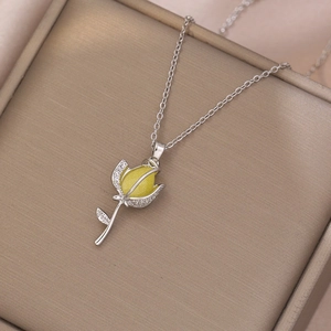 Close-up of tulip pendant necklace with yellow gemstone and shimmering pavé diamonds