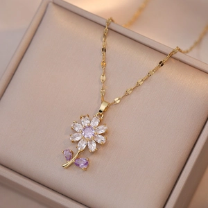 Golden flower necklace featuring purple zircon crystals and leaf detail in a jewelry box