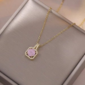 Elegant gold necklace featuring a pink round stone pendant with a square zircon frame