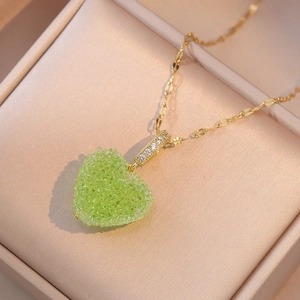 Minimalist golden necklace featuring a vibrant green crystal heart pendant for women