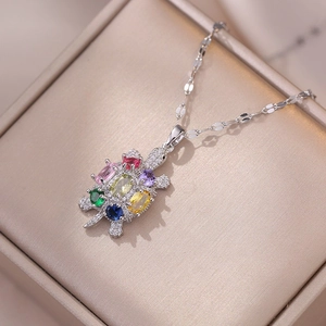 Macro shot of silver turtle pendant inlaid with vibrant multi-colored zircon gemstones