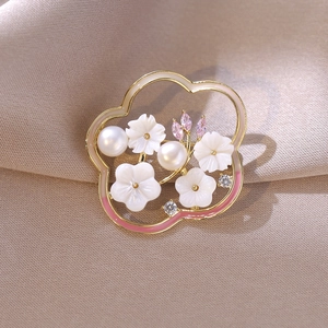 Detail einer floralen Emaille-Brosche mit Süßwasserperlen und Muschelblume auf Seide
