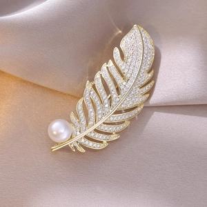Detailansicht der eleganten Federbrosche aus Gold mit weißer Perle und Zirkon-Steinen