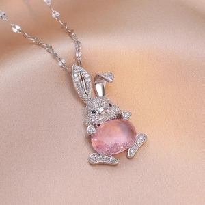 Collier pendentif lapin avec pierre rose et pavé de cristaux sur soie de couleur champagne