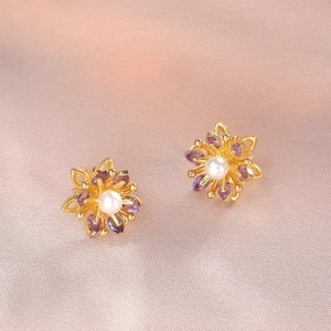 Elegante goldene Blumenstecker mit lila Markasit-Steinen und weißem Perlenzentrum