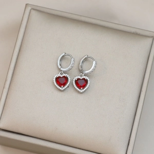 Pendientes de aro plateados con corazones rojos y halo de circonitas sobre caja de seda