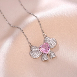 Collier élégant avec pendentif nœud, cristal cœur rose et incrustations de zircons