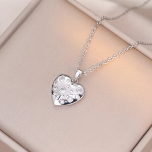 Collier pendentif cœur en argent avec zircons brillants dans un écrin en satin beige