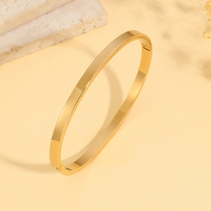 Minimalistische gepolijste goudkleurige roestvrijstalen ovale armband op elegant marmer