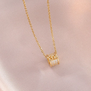 Collier en titane doré avec pendentif cylindre 1314 pavé de cristaux sur satin