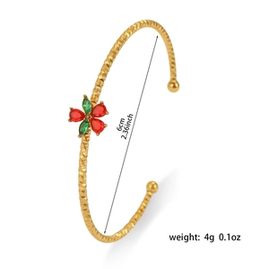 Detail of gold titanium steel bangle with red and green zircon flower and rhombic texture