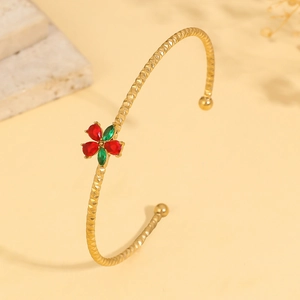 Detail of gold floral cuff bracelet with diamond-cut texture and colorful zircons