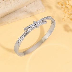 Close-up of silver geometric titanium bangle with pavé-set crystals in a rectangular motif