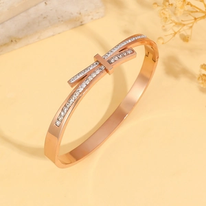 Detail of rose gold geometric bangle featuring double-layer knot and pave cubic zirconia