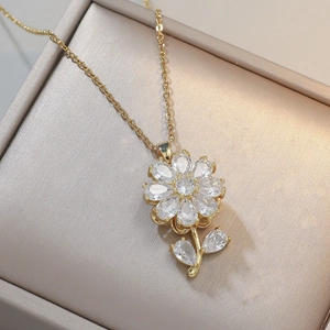 Elegante goudkleurige zonnebloem ketting met zirkoon blaadjes in een champagne juwelendoos