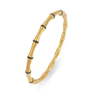 Detail van een goudkleurige roestvrijstalen armband met bamboe-ontwerp en zwarte steentjes