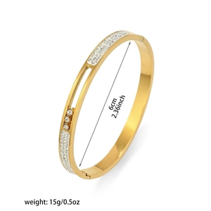 Detalle de brazalete de titanio dorado con diamantes móviles y medidas de dimensiones