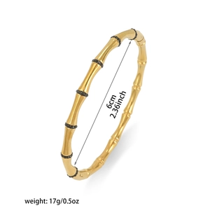 Detail van een gouden bamboe armband met zwarte steentjes en een diameter van 6 cm