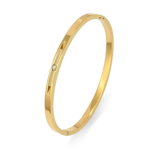 Detalle de brazalete de acero inoxidable dorado pulido con cristal y cierre de hebilla