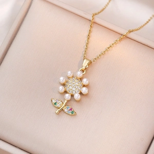 Golden flower necklace with white pearls and colorful zircon crystals on a jewelry box