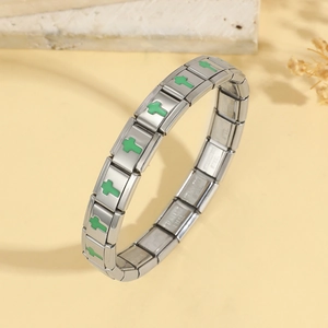 Macro view of stainless steel stretch bracelet links with green enamel cross charms