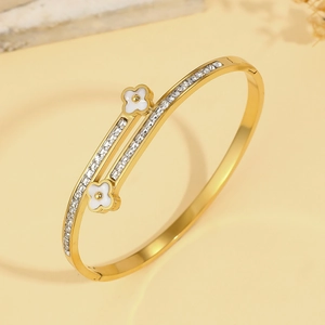 Eleganter Armreif aus Gold-Titanstahl mit weißen Kleeblatt-Motiven und Kristallen
