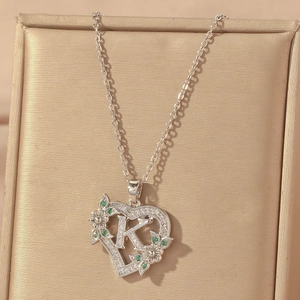 Heart pendant necklace with letter K and green zircons in luxury jewelry box