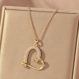 Elegante goldene Herzkette mit weißen Kristallen auf einer Schmuckschatulle