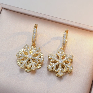 Elegante goldene Schneeflocken-Ohrringe mit glitzernden Zirkonia auf Schmuckbox