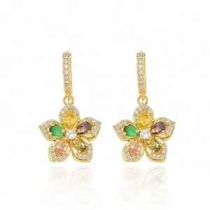 Detalle de pendientes de flor dorada con gemas de colores en forma de pera y circonitas