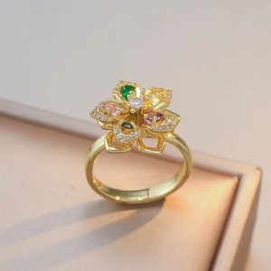 Exquisito anillo floral dorado con pétalos de circón multicolor y centro de cristal