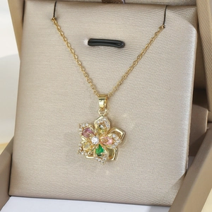 Exquisito collar dorado con colgante de flor multicolor en una elegante caja de regalo