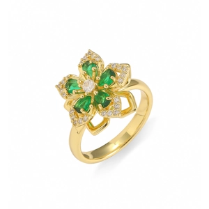 Macro d'une bague fleur dorée avec pétales émeraude et zircons étincelants incrustés