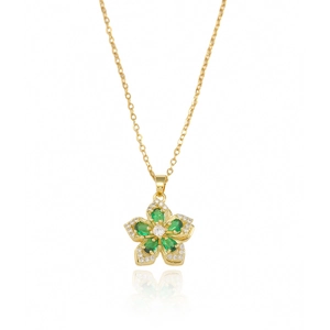Gros plan du collier doré avec pendentif fleur en pierre verte et oxydes de zirconium