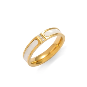Detail of gold shell ring with three vertical diamonds and white inlay finish