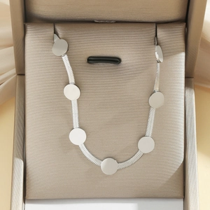 Detaillierte Makroansicht der silbernen Schlangenkette mit runden Anhängern in Geschenkbox