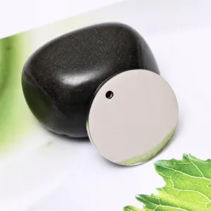 Macro detail of high-polish mirror finish on a round stainless steel pendant tag