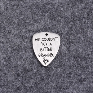 Guitar pick pendant in brushed stainless steel with heart engraving on grey felt
