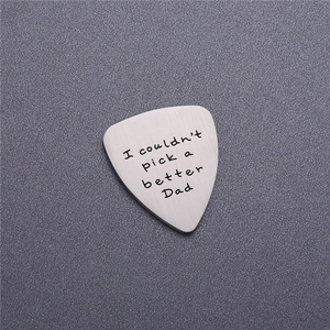 Macro shot of brushed stainless steel guitar pick engraved with I couldn't pick a better Dad