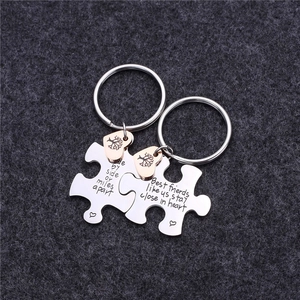 Close-up of interlocking stainless steel puzzle keychains with friendship engravings
