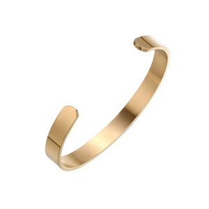Detail of C-shaped open cuff bangle with polished gold finish and brushed metal texture
