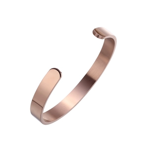 Detailed view of C-shaped rose gold cuff bracelet with brushed metal finish and smooth edges