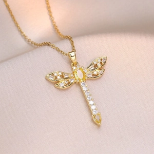 Collier libellule dorée orné de pierres jaunes et zircons sur un fond en soie douce