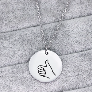 Collana in acciaio inossidabile lucido con ciondolo rotondo e disegno di un gesto a mano