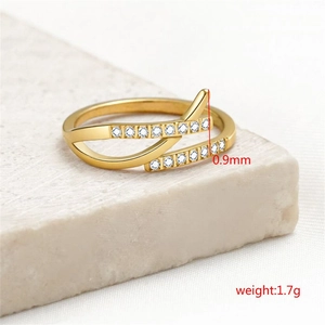 Detail eines 18k vergoldeten Edelstahl-Crossover-Rings mit Zirkonia auf Steinhintergrund