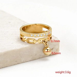Dettaglio macro dell'anello in acciaio al titanio dorato con fascia in zirconi e pendente